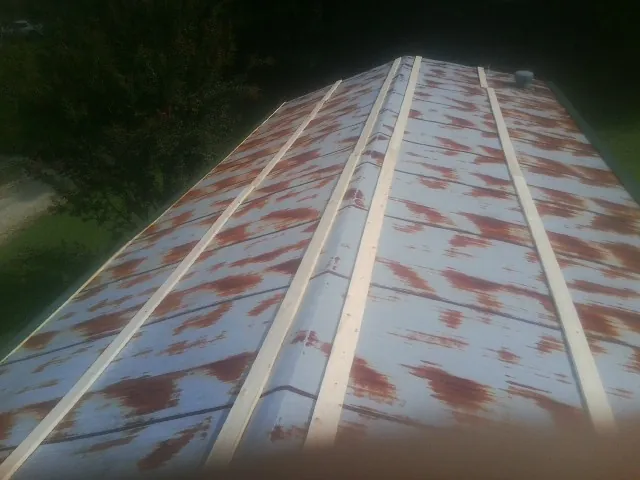 Rusted metal roof panels with new wood purlins before replacement — Storm Damage Roof Repair in Proctor by Roofing Brothers