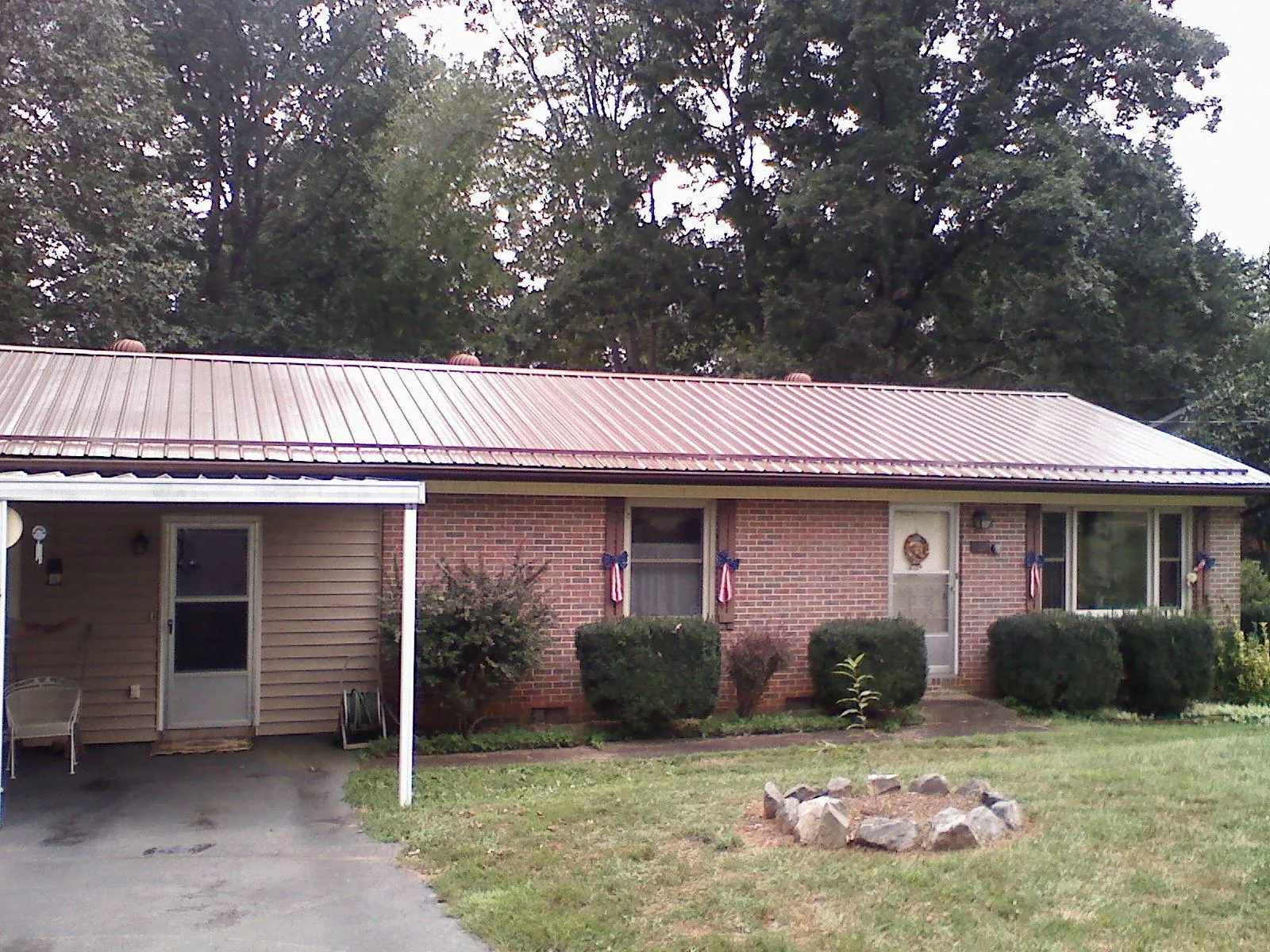 Bronze metal roof and carport on a brick ranch home — Roof Repair work by our crew in Proctor