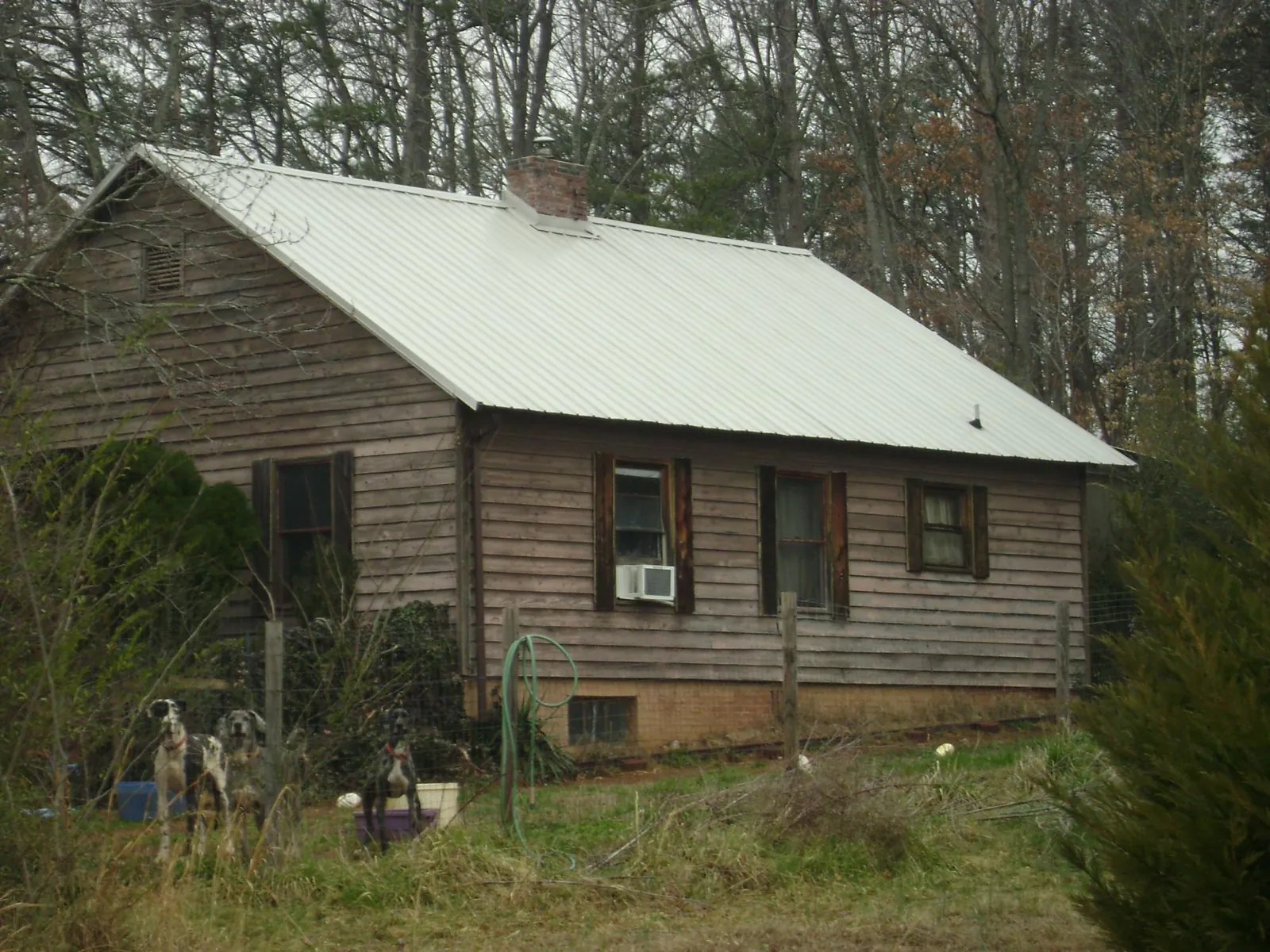 White metal roof on an old wood sided farmhouse, from a Metal Roof Installation job in Proctor